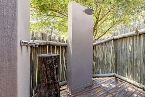 Una terraza de madera con un grifo de metal y un tocón de árbol.