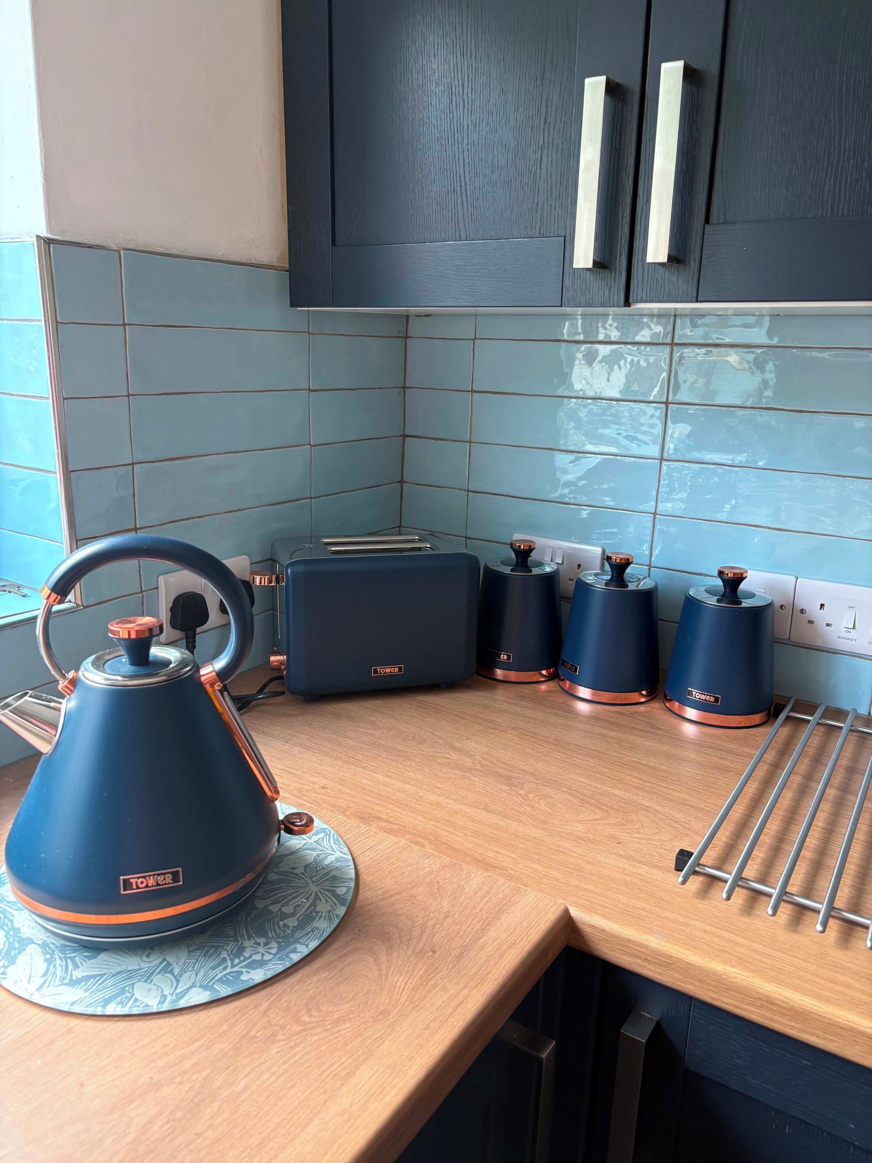 Una cocina con tetera, tostadora y hervidores eléctricos en la encimera.