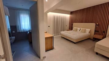 Ein modernes Hotelzimmer mit einem großen Bett, einem Nachttisch, einer Wand mit Holzvertäfelung und einer separaten Sitzecke.