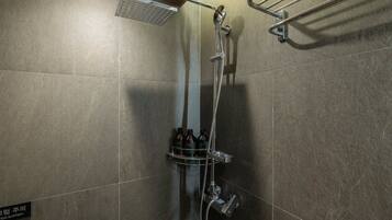 A shower area with a handheld showerhead, a wall-mounted hand dryer, and a towel rack.