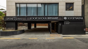 Entrada de um edifício com placas para 'FLOW SEOUL', 'LOOP SEOUL RETREAT BY ANOOK SEOUL GANGNAM2' e 'LOOP SAUNA'.