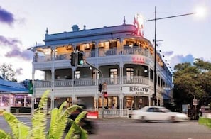 A multi-story building with balconies, a restaurant named 'Regatta,' and a sign with 'XXX' on the top. - Captivating Convenience! 1bed/1bath/1car/views (Brisbane)