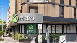 Een Metro restaurant met een moderne gevel, terras en een bord dat het einde van een parkeerzone 2P aangeeft.