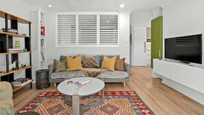 Een moderne woonkamer met een bank, salontafel en televisie.
