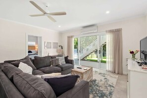 A modern living room with a sofa, coffee table, and a TV.