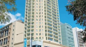 Un hotel de varios pisos con un núcleo central y balcones en cada planta.