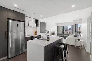 A modern kitchen with a central island, stainless steel appliances, and a city view. - Fab! Skyline CBD Views Over South Bank! (Brisbane)