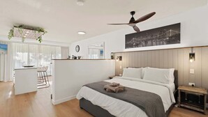Ein modernes Hotelzimmer mit einem großen Bett, einem Schreibtisch und Blick auf die Stadt.
