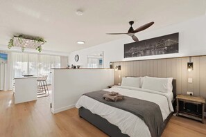 Ein modernes Hotelzimmer mit einem großen Bett, einem Schreibtisch und Blick auf die Stadt.