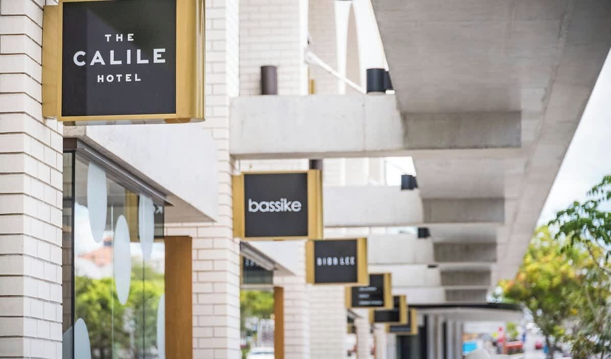 A hotel named 'The Calile Hotel' with signage for 'bassike' and 'BIRB LEE' businesses.