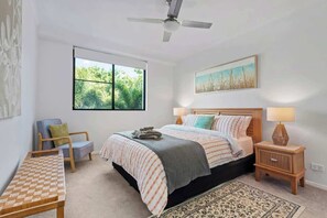 A bedroom with a bed, bedside tables, a chair, a window, and a ceiling fan. - New Farm Water Views! 2bed/2bath/1car (Brisbane)