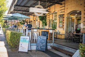 Ein Café mit Außenbereich, einer Speisekarte und einem Schild für Byron Bay Blend Kaffee.