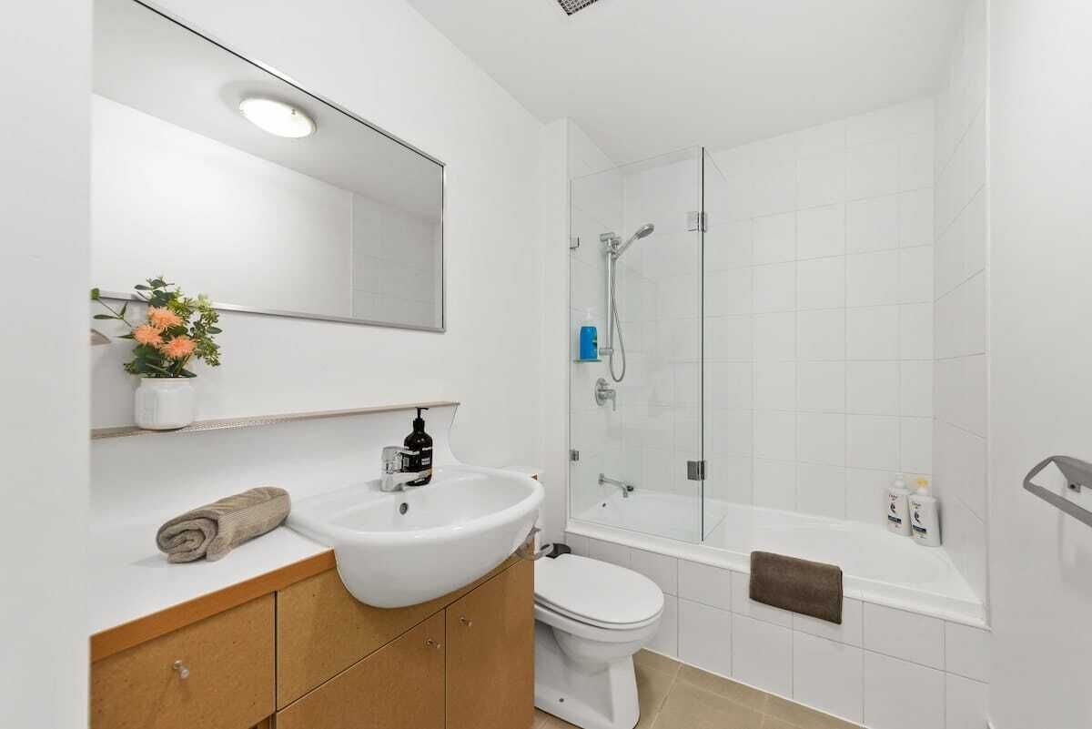 A modern bathroom with a sink, toilet, and shower.