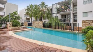 A modern building with a pool, balconies, and outdoor seating. - Home Away From Home! 2bed/1bath/car/pool~2kms CBD (Brisbane)