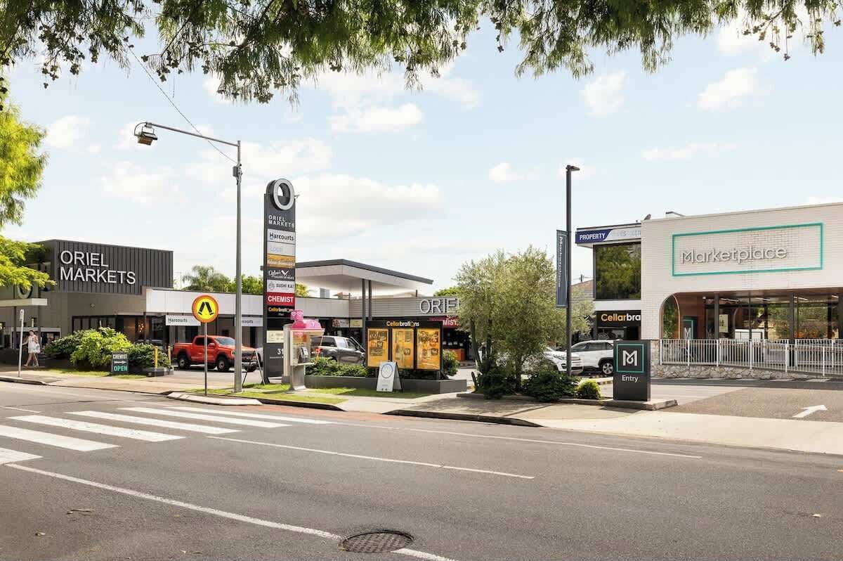 A street view with a Chevron gas station, a Marketplace store, and an ORIEL MARKETS store.