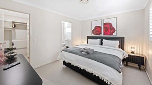 Une chambre à coucher comprenant un lit, une table de chevet, une commode et un placard.