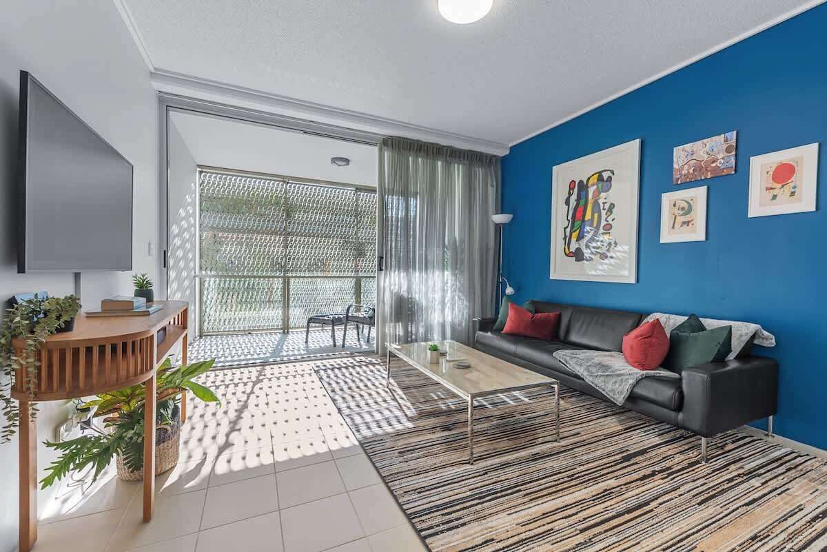 A modern living room with a sofa, coffee table, and artwork on the wall.