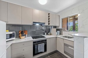 Eine moderne Küche mit Mikrowelle, Herd, Backofen und Geschirrspüler.