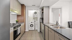 Cocina compacta con estufa, lavamanos y lavadora y secadora integradas.