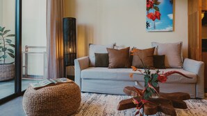 Ein modernes Wohnzimmer mit einer Couch, einem Hocker und einer stehenden Stehlampe.