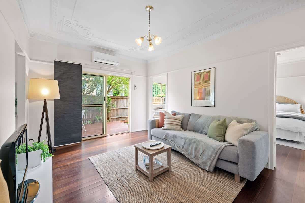 A living room with a sofa, a coffee table, a lamp, and a painting on the wall.