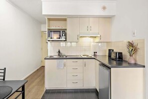 A compact kitchen with a microwave, toaster, and sink. - Two Seconds Toeverything! 1bed/1bath/1car/cbd Views (Brisbane)