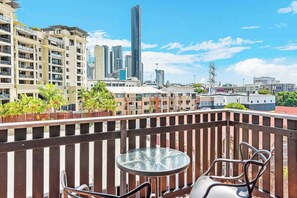 A balcony with a glass table and chairs, overlooking a cityscape with high-rise buildings. - Two Seconds Toeverything! 1bed/1bath/1car/cbd Views (Brisbane)