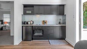 Une cuisine compacte dotée d’appareils électroménagers modernes, d’un lave-vaisselle et d’un four encastré.