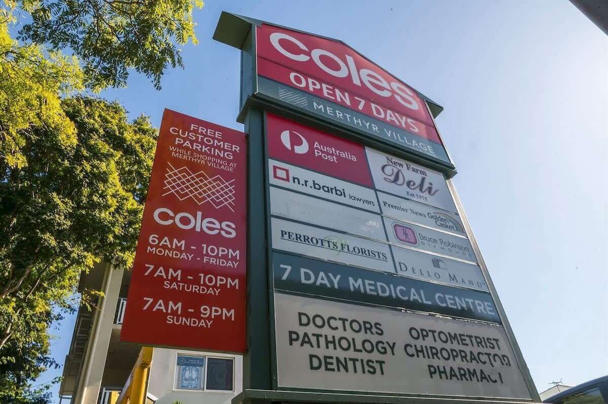 A signboard with a 7-day open notice for a store, free parking, and a 7-day medical center.