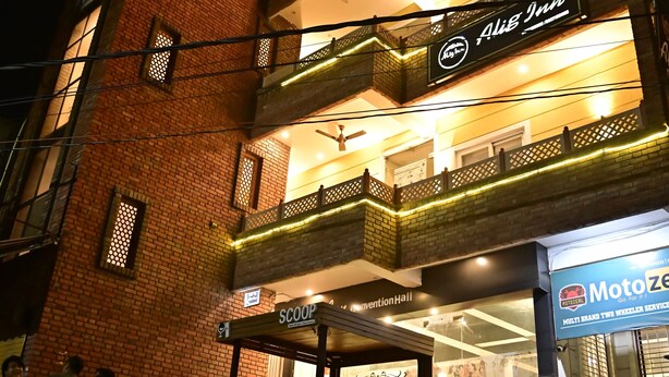 Un edificio de varios pisos con un restaurante llamado 'Alib Inn' y una tienda llamada 'Scoop'.