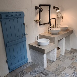 A bathroom with two sinks, a blue door, and patterned floor tiles. - Between land and sea (Saint-Méloir-des-Ondes)