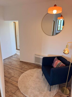 A modern living room with a dark blue sofa, a round rug, a round mirror, and a floor lamp. - La Fenêtre sur le Ventoux (Montbrun-les-Bains)