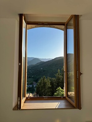 A room with a large open window offering a view of a mountainous landscape. - La Fenêtre sur le Ventoux (Montbrun-les-Bains)