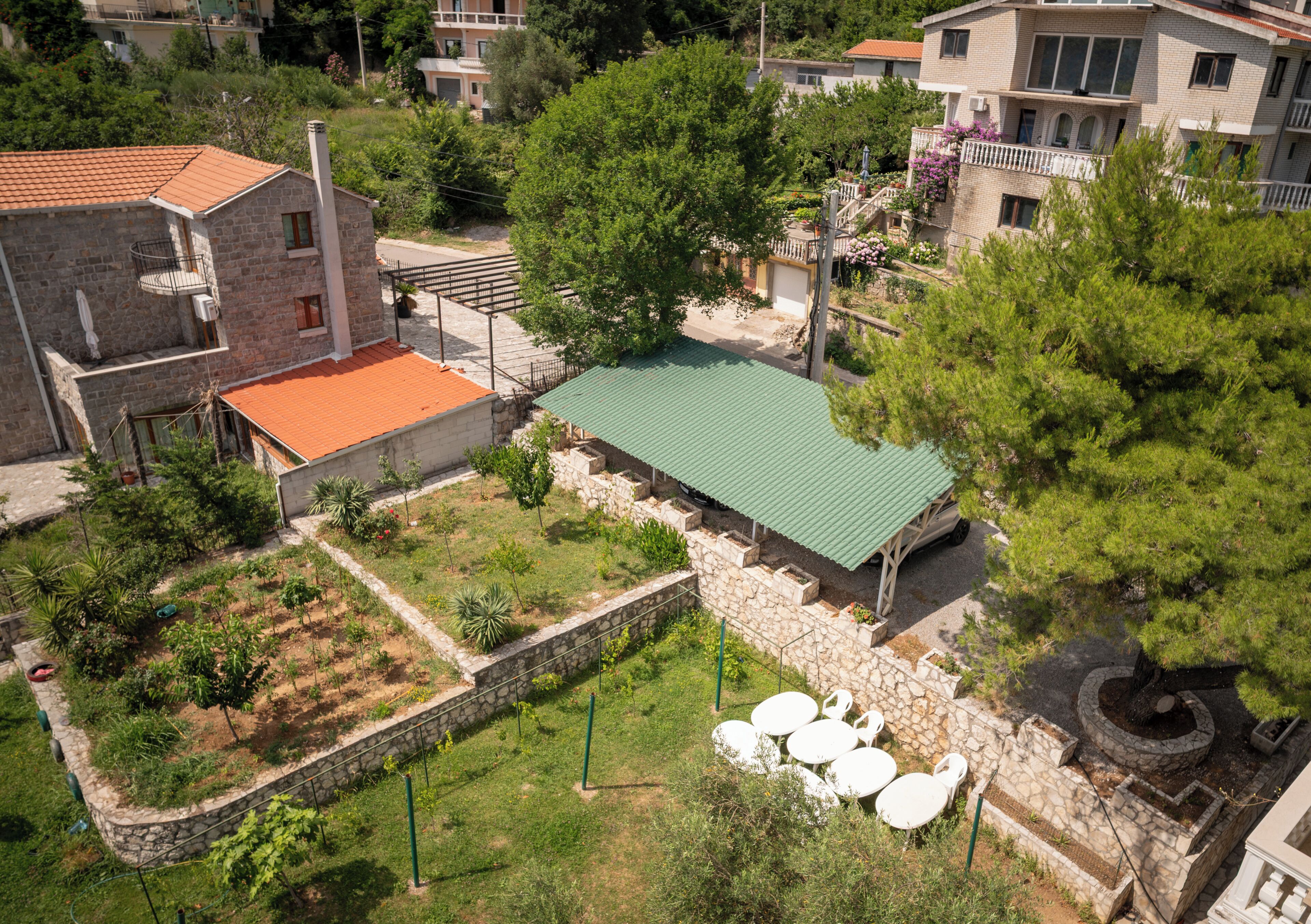 A residential area with stone buildings, a green-roofed structure, and outdoor seating.