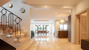 A spacious interior with a marble staircase, a dining area with a view, and a modern kitchen. - Ultra-Luxury 4-Bedroom en-suite self catering Villa in Zimbali Coastal Resort (Ballito)