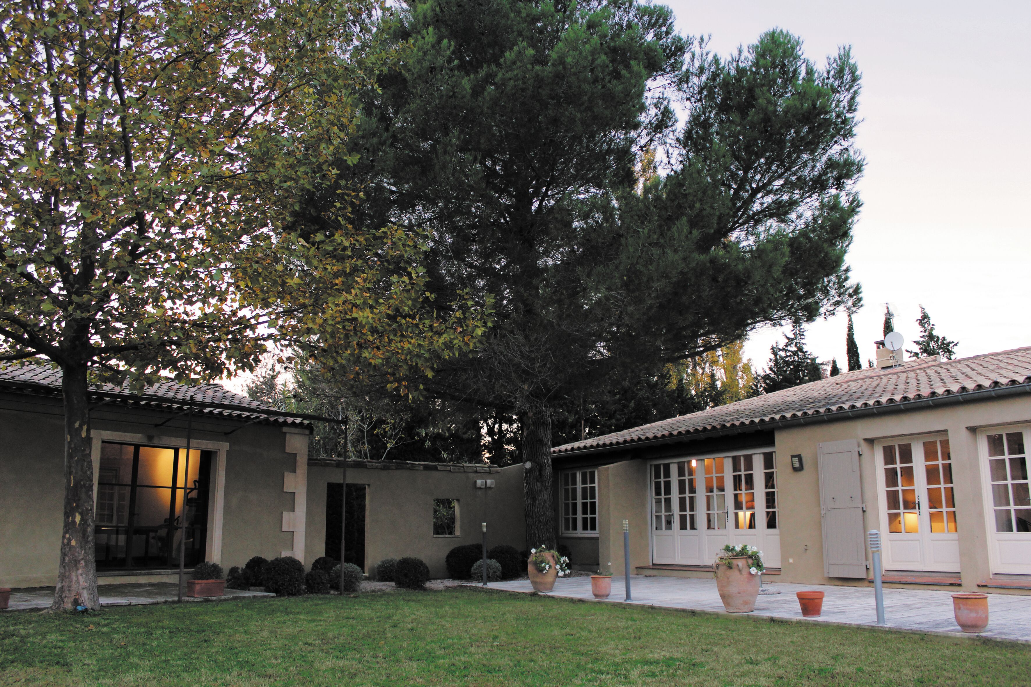 A building with a tiled roof, large windows, and a well-maintained lawn.