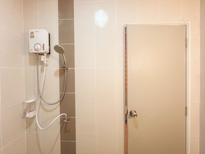 Un baño con ducha, inodoro y puerta.