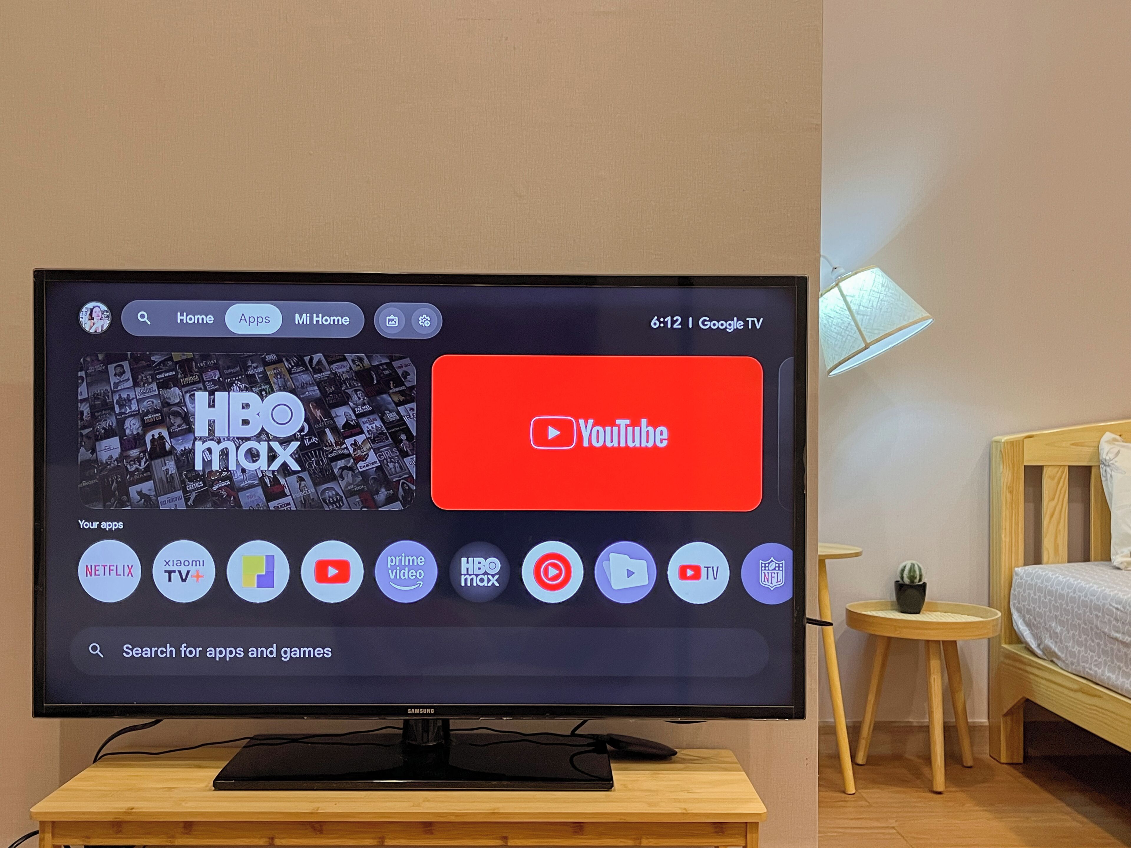 Een televisie toont een beginscherm met diverse app-icoontjes, waaronder YouTube en HBO Max.