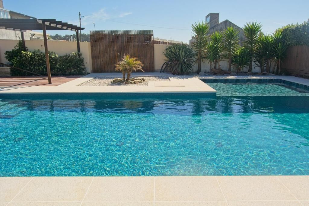Una piscina al aire libre de temporada, sillones reclinables de piscina