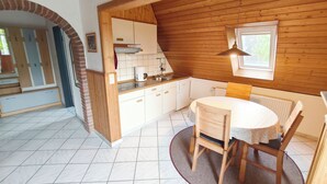 A kitchen with white cabinets, a wooden countertop, and a window. - Vacation apartment on the North Sea - Holtgast (East Frisia) (Holtgast)