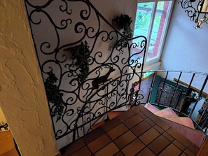 A staircase with ornate metal railings and a decorative wall.