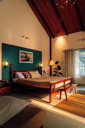 A bedroom with a bed, bedside tables, a lamp, and a window with curtains.