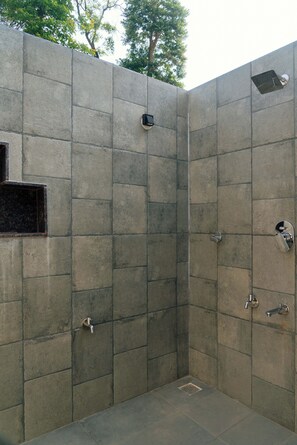 Un espace de douche en pierre avec un siège intégré et une petite fenêtre.