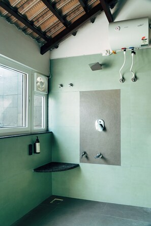 Une salle de bain avec une fenêtre, une douche, un lavabo et un porte-serviettes.