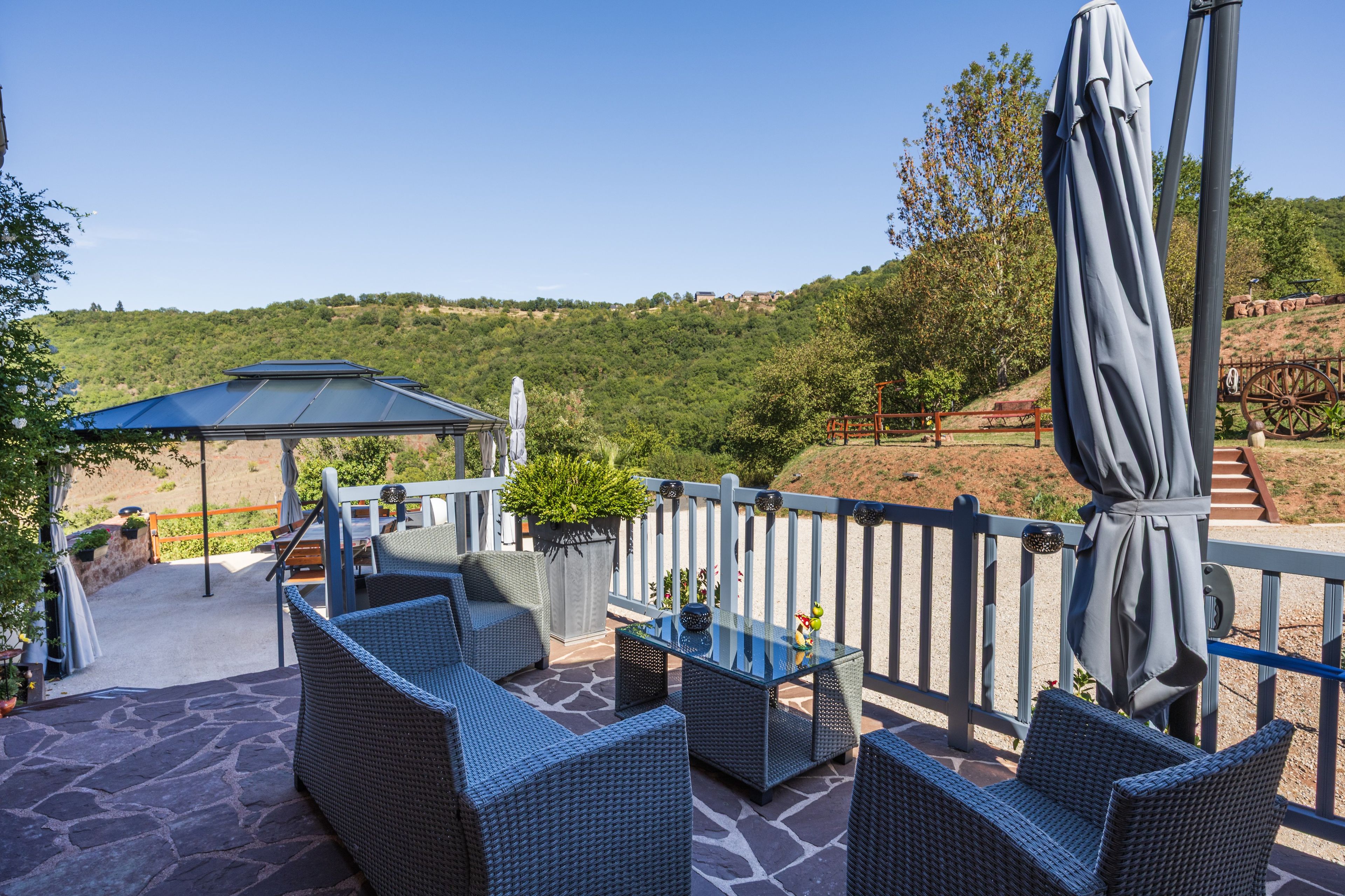 A patio area with wicker furniture, a table, and a covered seating area.