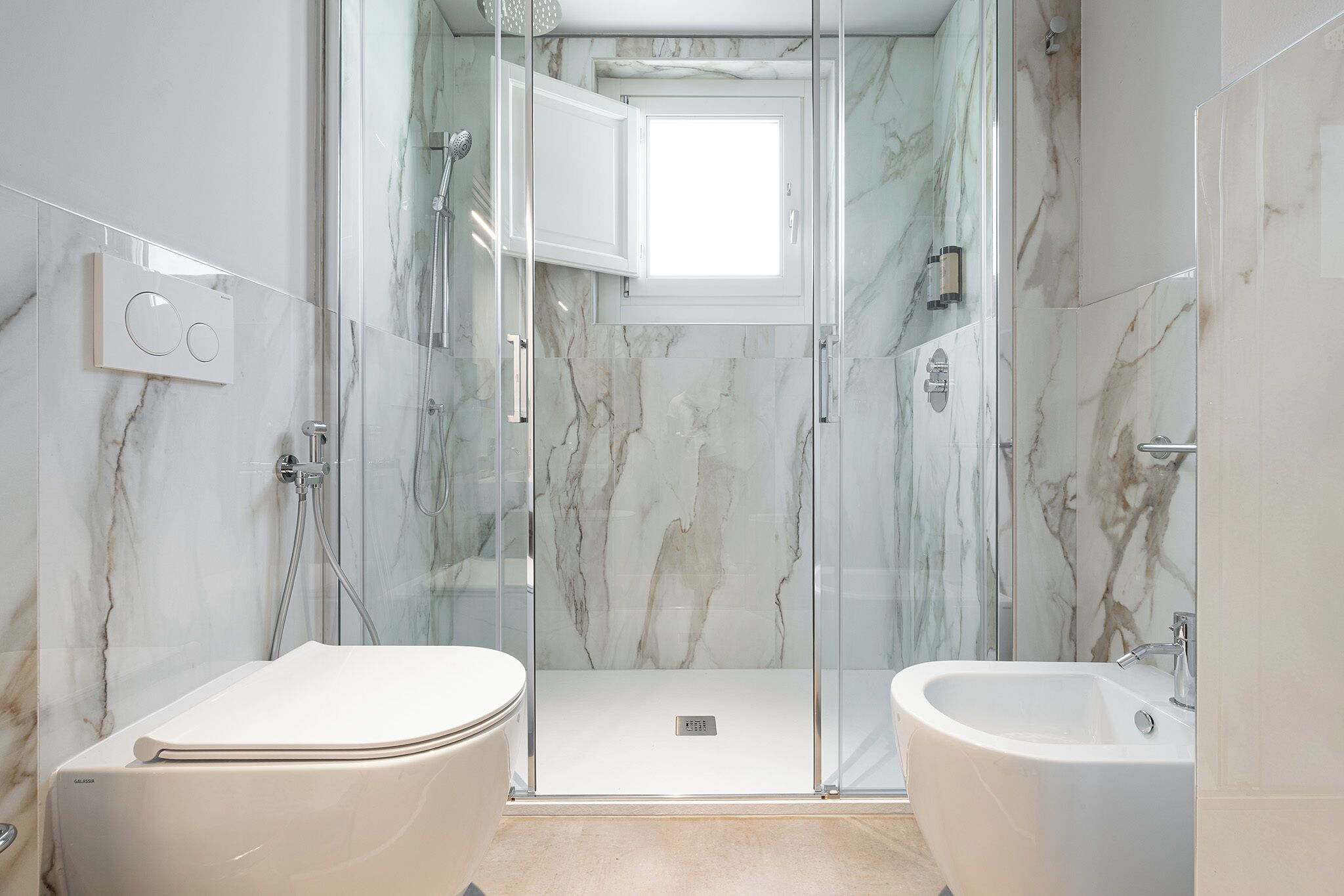Un bagno moderno con doccia vetrata, un water e una vasca da bagno.