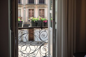 Una vista attraverso una porta, con ringhiera in metallo e fioriere.