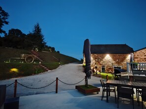 A stone building with a wheelchair ramp, outdoor seating, and a barbecue area. - “Sans Chichi Chambres Et Table” Guesthouse with Shared Terrace, Garden, and Wi-Fi (Escandolières)