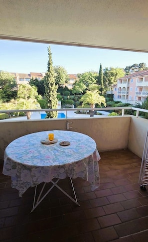 Ein Balkon mit rundem Tisch, einem Stuhl und einer kleinen Pflanze.