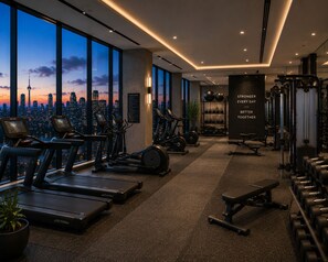 A gym with treadmills, exercise bikes, and weight equipment, with a cityscape view. - Sunway Pyramid by Resort Suites (Petaling Jaya)